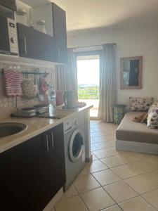 a kitchen with a sink and a washing machine at Appart hôtel Cabo dream in Cabo Negro