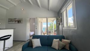 a living room with a blue couch and a window at Pieds dans l eau Piscine Calme Appartement Althéa in Le Gosier +21 photos