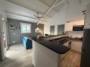a kitchen with a counter top and a blue couch at Pieds dans l eau Piscine Calme Appartement Althéa in Le Gosier