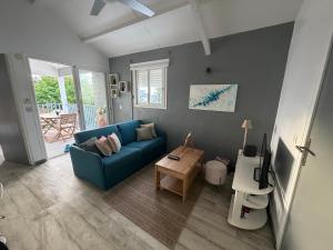 a living room with a blue couch and a table at Pieds dans l eau Piscine Calme Appartement Althéa in Le Gosier