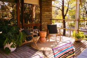 a screened in porch with two chairs and a table at A charming escape from everyday life in Aireys Inlet