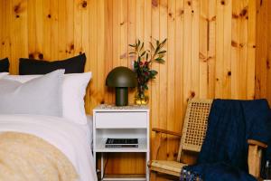 a bedroom with a bed with a night stand and a chair at A charming escape from everyday life in Aireys Inlet