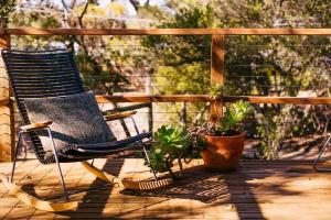 a rocking chair and potted plants on a deck at A charming escape from everyday life in Aireys Inlet