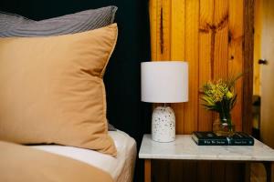 a bed with a lamp on a table with a pillow at A charming escape from everyday life in Aireys Inlet +15 photos