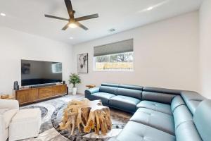 a living room with a blue couch and a table at Modern Lago Vista Home with Balcony, Patio, Gas Grill, WIFI, and AC in Lago Vista