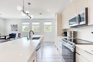 a white kitchen with a sink and a counter at Modern Lago Vista Home with Balcony, Patio, Gas Grill, WIFI, and AC in Lago Vista