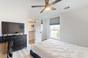 a bedroom with a bed and a flat screen tv at Modern Lago Vista Home with Balcony, Patio, Gas Grill, WIFI, and AC in Lago Vista