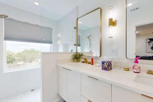 a white bathroom with a sink and a mirror at Modern Lago Vista Home with Balcony, Patio, Gas Grill, WIFI, and AC in Lago Vista +15 photos