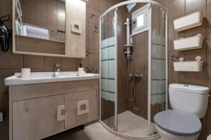 a bathroom with a shower and a toilet and a sink at Chill Coast House in Nisís Áyios Nikólaos +52 photos
