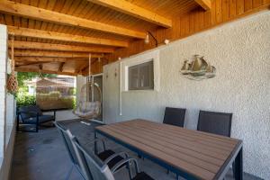 a patio with a wooden table and chairs at Chill Coast House in Nisís Áyios Nikólaos
