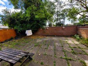 a patio with a bench and a brick wall at Lindi Property Cosy Double Room in Wyken