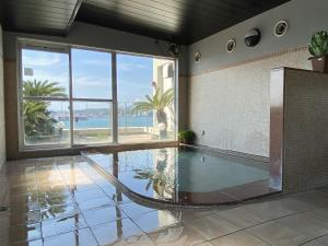 a swimming pool with a hammock in a room at Hotel Route-Inn Mojiko in Kitakyushu