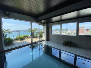 a house with a swimming pool with a view of the ocean at Hotel Route-Inn Mojiko in Kitakyushu