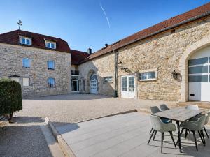 a patio with a table and chairs in front of a building at Suite Le Mans 70 in Pusey