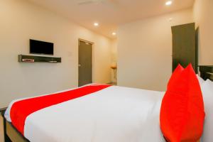 a bedroom with a large bed with red pillows at SPOT ON Pnd Complex in Hyderabad