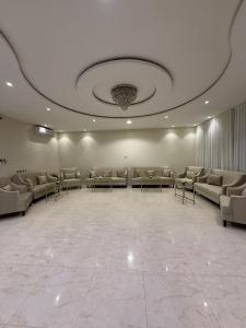 a large waiting room with couches and tables and a ceiling at سفانه in Unayzah