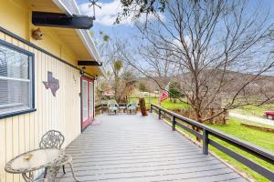 a wooden porch with chairs and tables on a house at Cozy Dog-Friendly House Near Water with Enclosed Yard, Grill, & Equipped Kitchen in Burnet