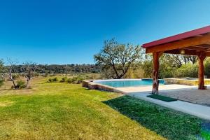 a backyard with a swimming pool and a pavilion at 4-Bedroom Spacious Home with Guest House & Pool, Located on 9 Acres of Land in Spicewood