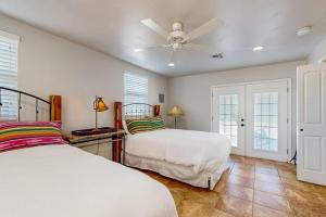 a bedroom with two beds and a ceiling fan at 4-Bedroom Spacious Home with Guest House & Pool, Located on 9 Acres of Land in Spicewood +38 photos