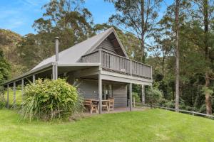 a house with a gambrel roof and a deck at Alcheringa Cottage Amazing Location with views in Kangaroo Valley