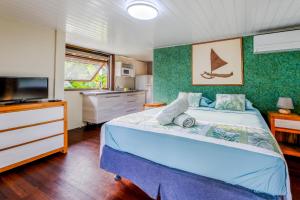 a bedroom with a blue bed and a television at Fare Aute Beach in Vaianae