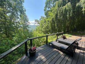 a wooden deck with a bench and potted plants on it at Edge View Chalet in Bryson City