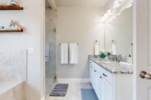 a white bathroom with a sink and a shower at Cozy Lago Vista Home with Private Pool Table, Mile From The Stunning Lake Travis in Lago Vista +19 photos