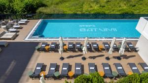 an overhead view of a swimming pool with lounge chairs and a swimming pool at Mira Seaview Studio Apartment in Batumi in Batumi