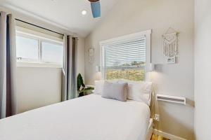 a bedroom with a white bed and a window at Modern Tiny Home with Loft, Kitchen, Cozy Patio and Shared Pools, Great Location in Fredericksburg +14 photos