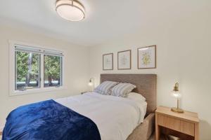 a white bedroom with a large bed and a window at Maevebrook in Sister Bay