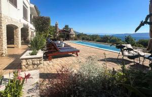 a house with a swimming pool next to a house at Apartment Ravni V in Labin