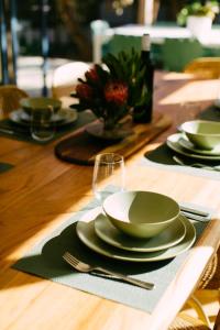 a wooden table with plates and bowls and a wine glass at Perfect Beachside Escape - Walk Everywhere in Anglesea +21 photos