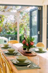 a table with plates and a vase of flowers on it at Perfect Beachside Escape - Walk Everywhere in Anglesea