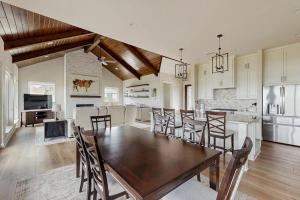a kitchen and dining room with a wooden table and chairs at Spacious House with Ping-Pong and Pool Table, Balcony with Water and Sunset View in Point Venture