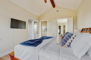 a bedroom with a white bed and a television at Spacious House with Ping-Pong and Pool Table, Balcony with Water and Sunset View in Point Venture
