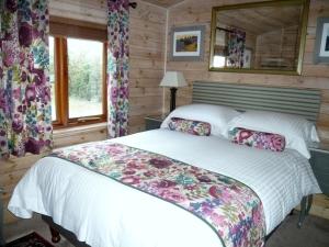 a bedroom with a bed in a log cabin at Charming Cottage in Romney Marsh Britain with Wooden Deck in Ivychurch