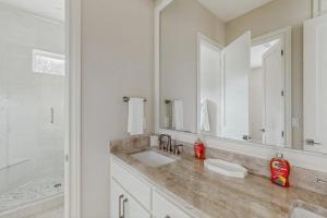 a bathroom with a sink and a large mirror at Spacious House with Ping-Pong and Pool Table, Balcony with Water and Sunset View in Point Venture +16 photos