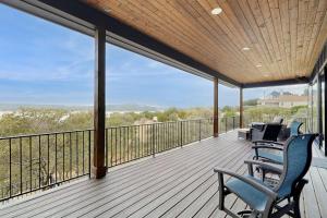 a deck with chairs and tables on a balcony at Spacious House with Ping-Pong and Pool Table, Balcony with Water and Sunset View in Point Venture