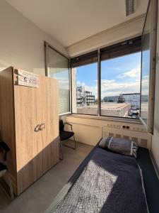 a bedroom with a bed and a large window at Haus an der Brücke in Munich