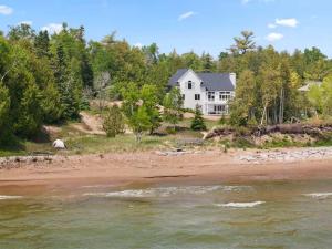 a white house on the shore of a river at Dune Alright by Simple Life Rentals in Baileys Harbor