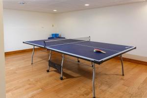a ping pong table with a tennis racket on it at Dune Alright by Simple Life Rentals in Baileys Harbor