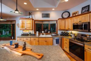 a kitchen with wooden cabinets and a clock on the wall at Asher Manor by Simple Life Rentals in Egg Harbor +31 photos