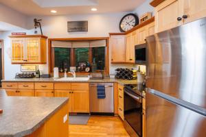 a kitchen with wooden cabinets and a clock on the wall at Asher Manor by Simple Life Rentals in Egg Harbor