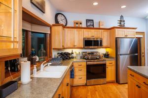 a kitchen with wooden cabinets and a stainless steel refrigerator at Asher Manor by Simple Life Rentals in Egg Harbor