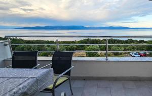 a balcony with a table and chairs and a view of the water at Apartment Labin Ravni in Labin