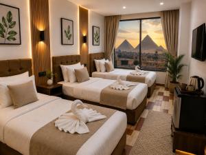 a hotel room with three beds with a view of the pyramids at Giza Pyramids view hotel in Giza +36 photos