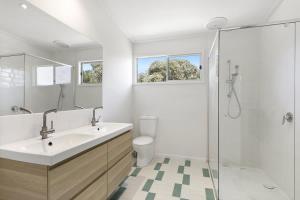 a white bathroom with a sink and a shower at Beach at Your Doorstep - Pet Friendly in Anglesea +10 photos
