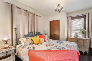 a bedroom with a bed with colorful pillows and a chandelier at Stowaway Lower Deck in Sturgeon Bay