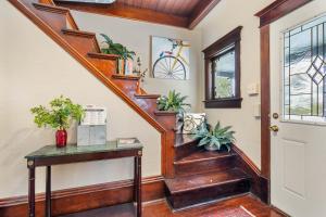 a hallway with a wooden staircase with potted plants at Stowaway Lower Deck in Sturgeon Bay