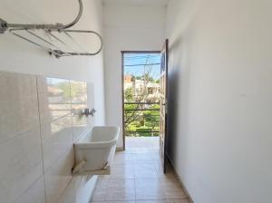a bathroom with a tub and a sink and a window at Departamentos Marconi 1B in Resistencia +47 photos